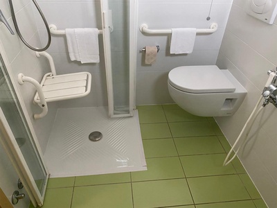 Bagno, doccia con seggiolino abbassato e tazza